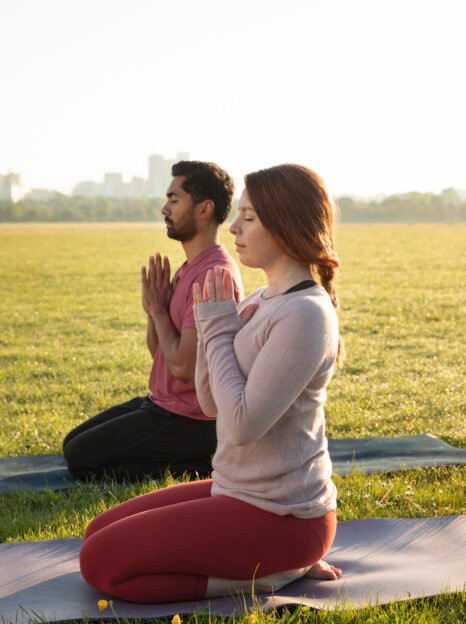 side-view-man-woman-meditating-outdoors-yoga-mats