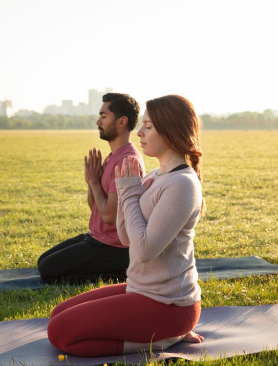 side-view-man-woman-meditating-outdoors-yoga-mats